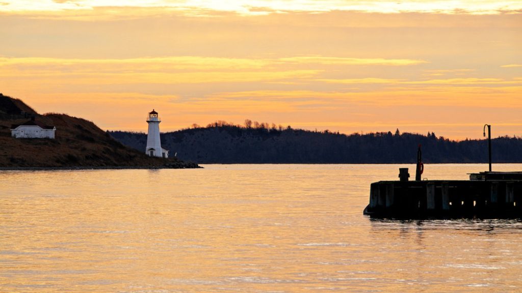 Sunset view of Halifax Harbour waterfront with lighthouse and dock, Nova Scotia