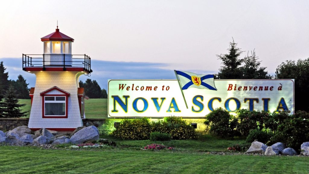 Welcome to Nova Scotia bilingual road sign with lighthouse and Nova Scotia flag, Atlantic Canada